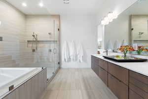 Bathroom featuring tile flooring, vanity, and plus walk in shower