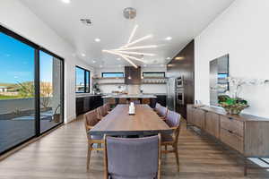 Dining space with light hardwood / wood-style flooring and a notable chandelier