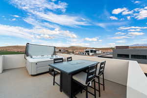 View of patio / terrace with a mountain view and a hot tub