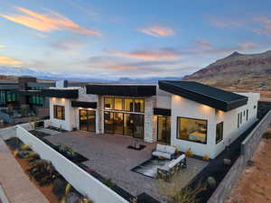 Back house at dusk with a patio area and a mountain view