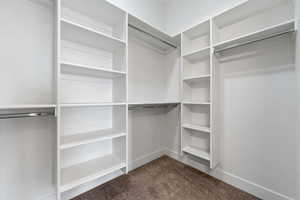 Walk in closet with dark carpet