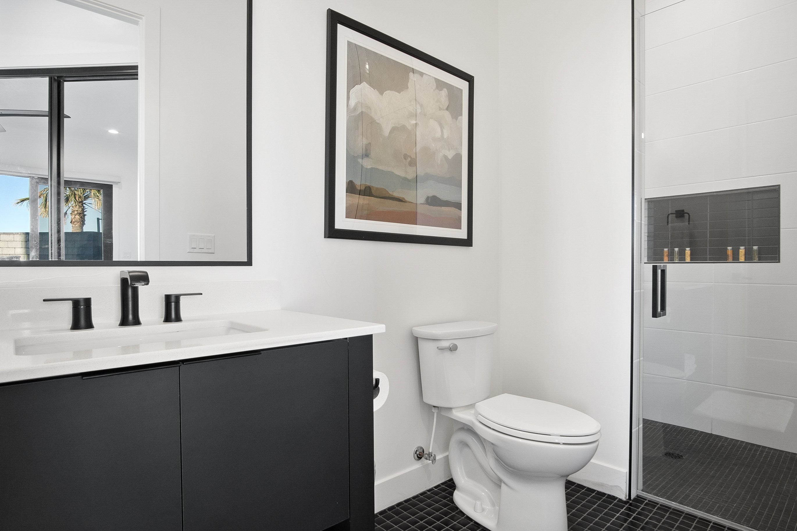 Bathroom featuring an enclosed shower, vanity, tile floors, and toilet