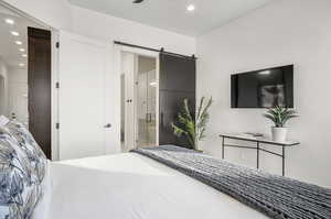 Bedroom featuring connected bathroom and a barn door