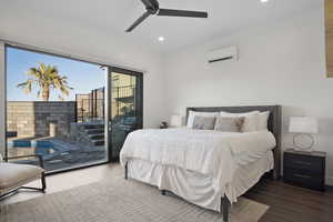 Bedroom featuring wood-type flooring, ceiling fan, a wall mounted air conditioner, and access to outside