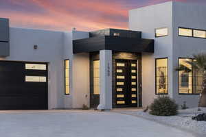 Exterior entry at dusk featuring a garage