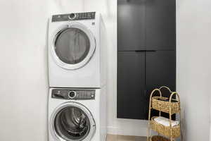 Washroom with stacked washer / dryer and tile floors