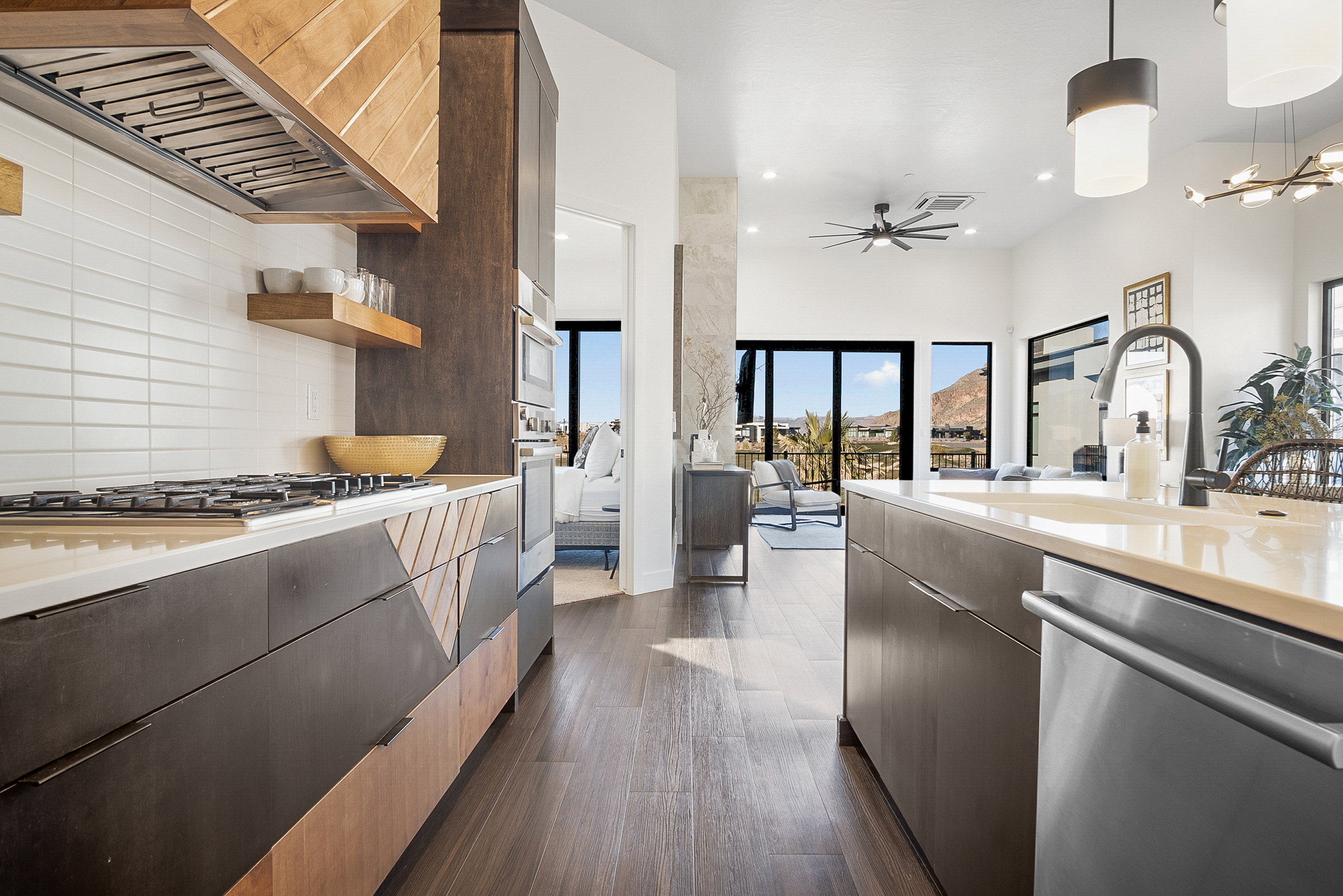 Kitchen featuring appliances with stainless steel finishes, custom exhaust hood, tasteful backsplash, decorative light fixtures, and dark hardwood / wood-style floors