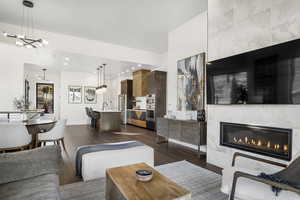 Living room with sink, dark hardwood / wood-style flooring, an inviting chandelier, and a large fireplace