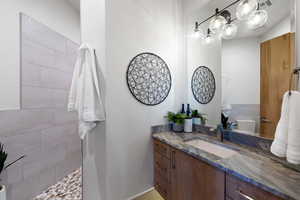 Bathroom with vanity with extensive cabinet space and toilet