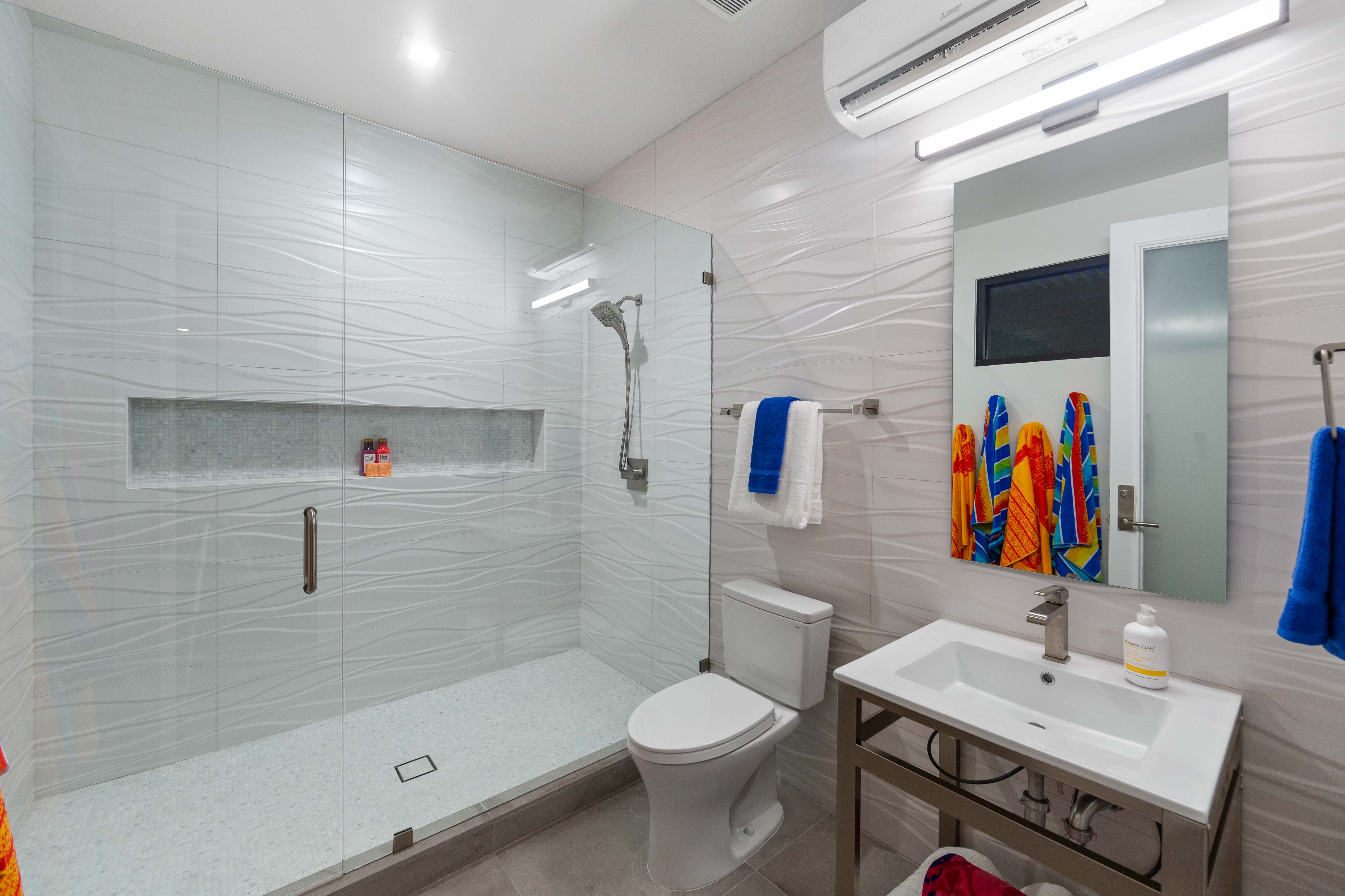 Bathroom featuring a shower with shower door, toilet, tile flooring, and tile walls