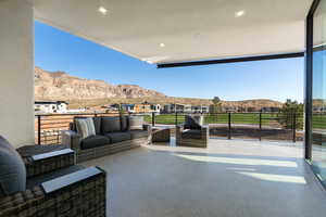 Exterior space featuring a mountain view, a balcony, and an outdoor hangout area