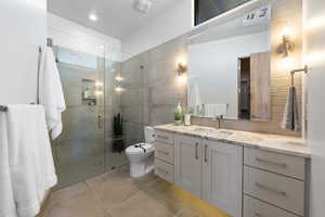 Bathroom with tile flooring, vanity, an enclosed shower, and toilet