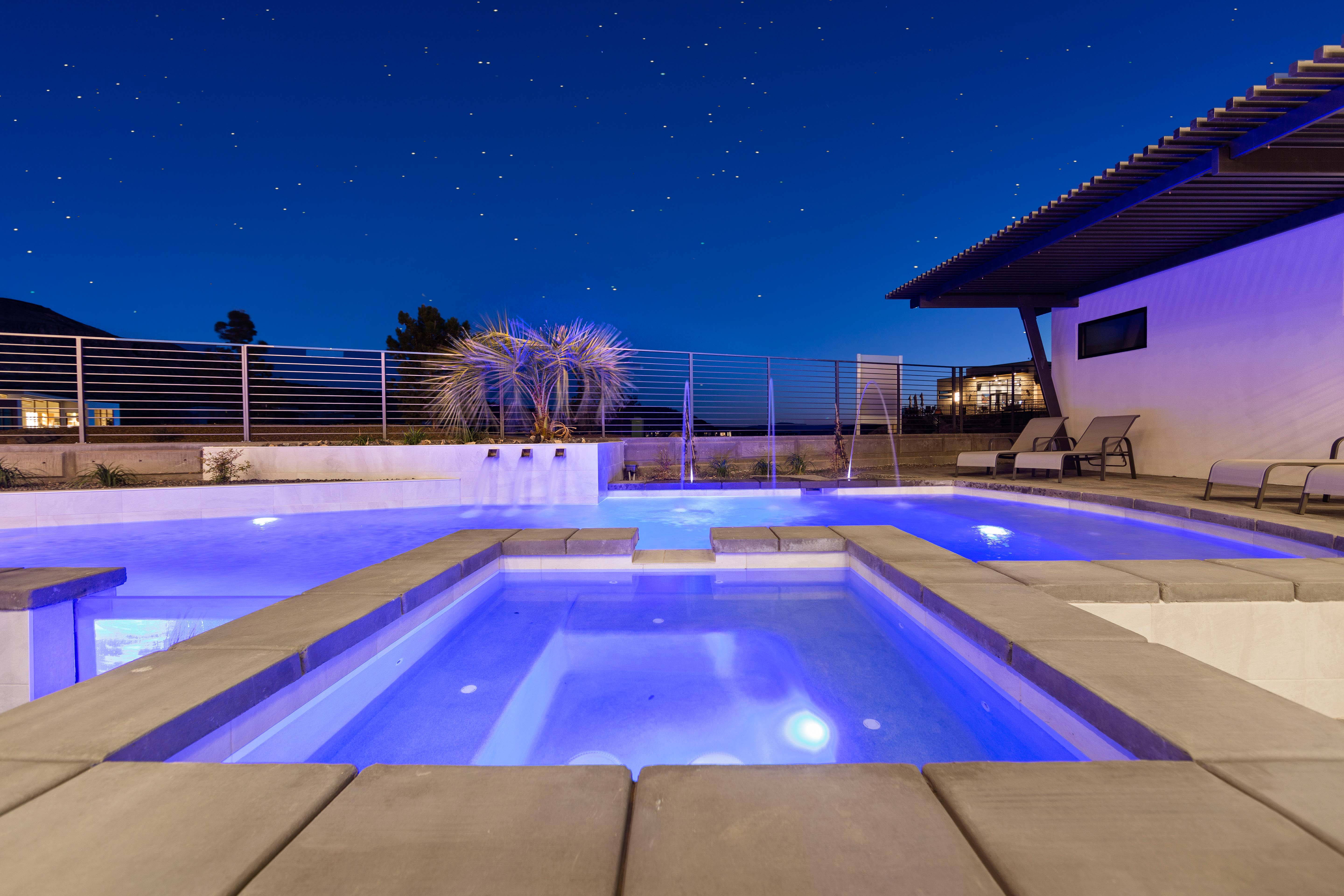Pool at night featuring a patio area