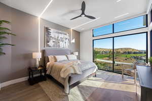 Bedroom with hardwood / wood-style floors, ceiling fan, and access to exterior