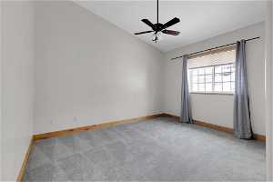 Empty 2nd bedroom with lofted ceiling, ceiling fan, and light carpet