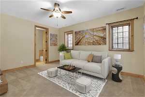1st bedroom depicted as a living room with ceiling fan, light colored carpet, and a healthy amount of sunlight