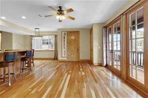 Living room with a healthy amount of sunlight, light hardwood / wood-style flooring, ceiling fan