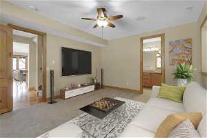 1st bedroom depicted as a living room featuring ceiling fan and light colored carpet