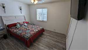 Bedroom featuring LVT flooring, ceiling fan, and ornamental molding