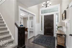 Foyer entrance with an inviting chandelier and dark hardwood floors