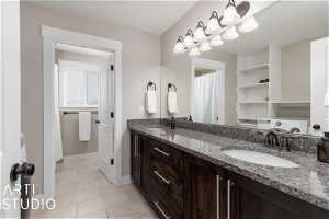 Bathroom featuring double vanity, washer / clothes dryer, and tile flooring