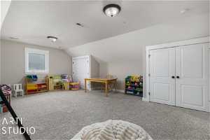 Game room with light colored carpet and vaulted ceiling