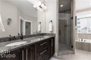 Bathroom with dual bowl vanity, shower with separate soaker bathtub, and tile flooring
