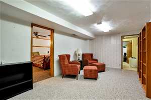 Living area with ceiling fan and light carpet