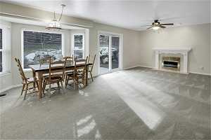 Dining/family room space with light carpet, ceiling fan, and a gas fireplace