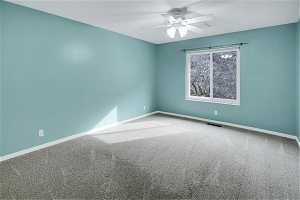 Bedroom one with ceiling fan and light colored carpet
