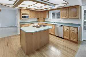 Kitchen featuring light hardwood oak floors, a center island, sink, and stainless steel appliances