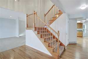 Stairs in main foyer with light hardwood floors