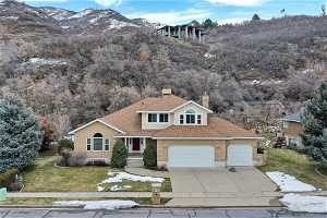 Front facade with lawn, 3 can garage, and an amazing mountain view