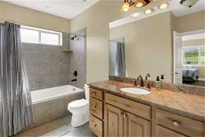 Full bathroom for north basement bedroom with large vanity, tile floors, shower / tub combo, and toilet