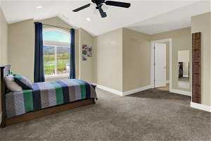 South upstairs bedroom featuring ceiling fan, dark carpet, and vaulted ceiling