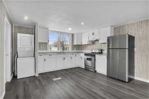 Kitchen with white cabinets, dark hardwood / wood-style flooring, electric range, and stainless steel fridge