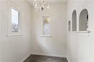 Interior space featuring a notable chandelier and dark tile floors and beautiful windows to allows