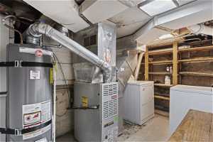 Utility room with washing machine and dryer and water heater