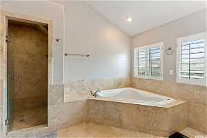 Bathroom with tile floors, shower with separate bathtub, and vaulted ceiling