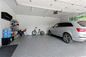 Garage featuring a garage door opener and a carport
