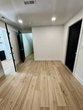 Spare room featuring a textured ceiling and light wood-type flooring