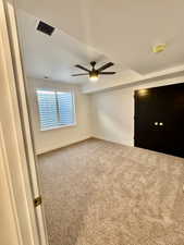 Carpeted spare room featuring ceiling fan