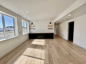 Unfurnished living room featuring light wood-type flooring and a textured ceiling