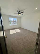 Empty room featuring ceiling fan, a textured ceiling, and carpet