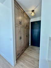 Mudroom with a textured ceiling and light wood-type flooring