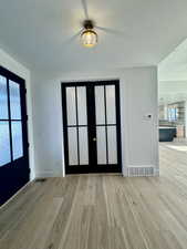 Entryway with light hardwood / wood-style floors, french doors, and a textured ceiling