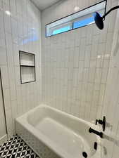 Bathroom with tile patterned flooring and tiled shower / bath