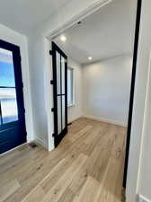 Foyer with a textured ceiling and light hardwood / wood-style flooring