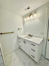 Bathroom with vanity and a textured ceiling