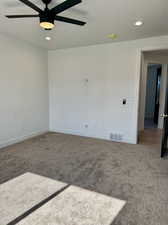 Carpeted spare room featuring ceiling fan